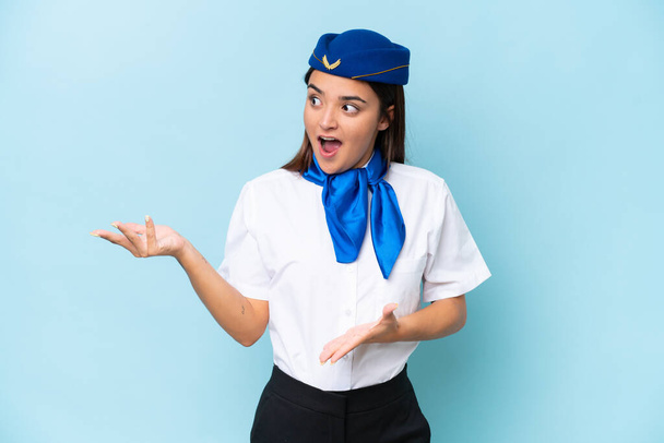 Airplane stewardess caucasian woman isolated on blue background with surprise facial expression - Fotoğraf, Görsel
