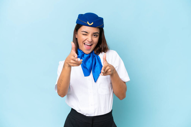 Стюардесса самолета белая женщина изолирована на синем фоне, указывая на фронт и улыбаясь - Фото, изображение