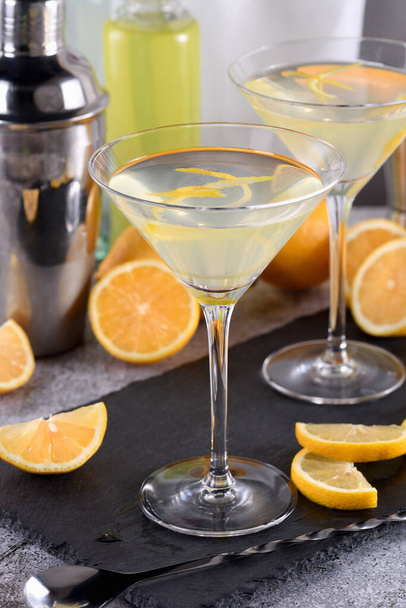 Martini z cytryną z nutką smaku oferuje wyrafinowany twist do koktajlu. Ten lekki i pikantny ulubiony łączy wódkę, likier pomarańczowy, świeży sok z cytryny i zest. - Zdjęcie, obraz