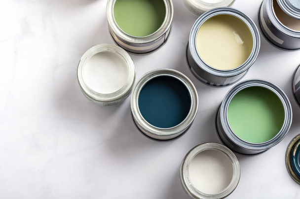 Tiny sample paint cans during house renovation, process of choosing paint for the walls, different green and beige colors, color charts on background - Fotoğraf, Görsel