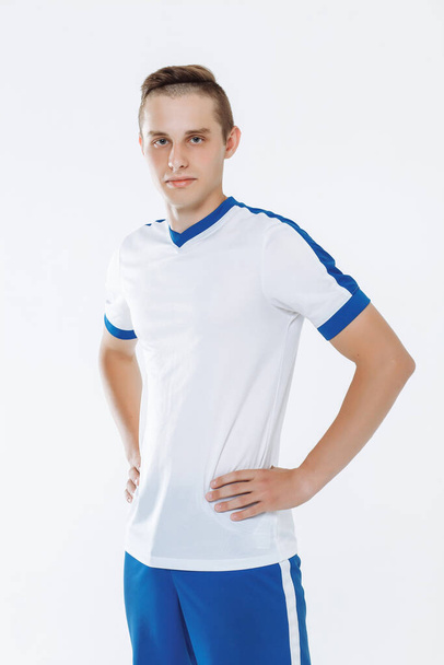 Football player in white and blue uniform against a white background. High quality photo - Fotó, kép