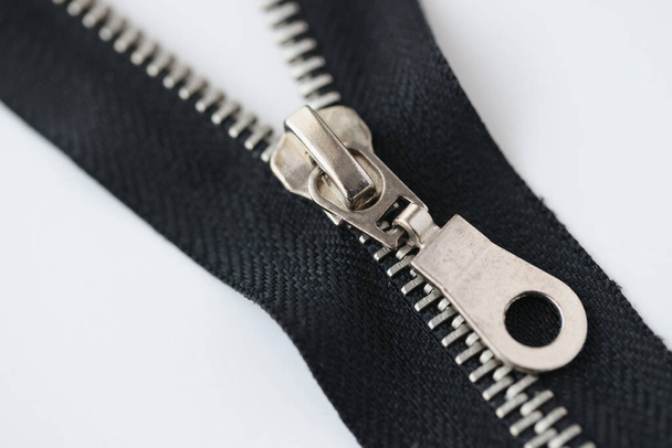 Metallic zipper isolated on white background. Black zipper lock close up. - Foto, imagen