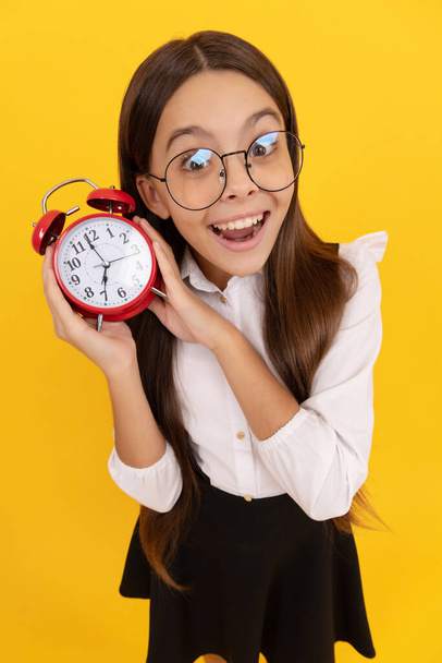 punctuality. last chance. punctual teen girl checking time. amazed nerd child listen the alarm clock ringing. school kid in uniform and glasses showing time. you are late. deadline. good morning. - Fotó, kép