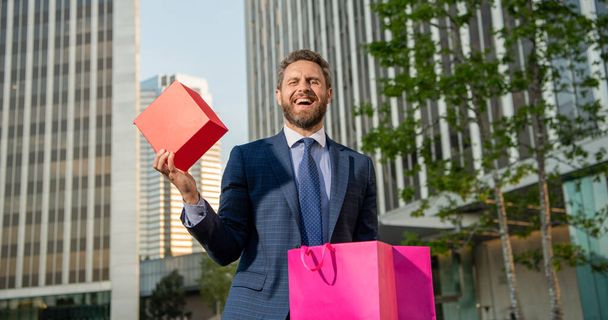happy businessman with package. sale and discount. surprise for her. be my valentine. boxing day. handsome man with present box. entrepreneur carry birthday gift. guy hold shopping bag. mens day. - Foto, Bild