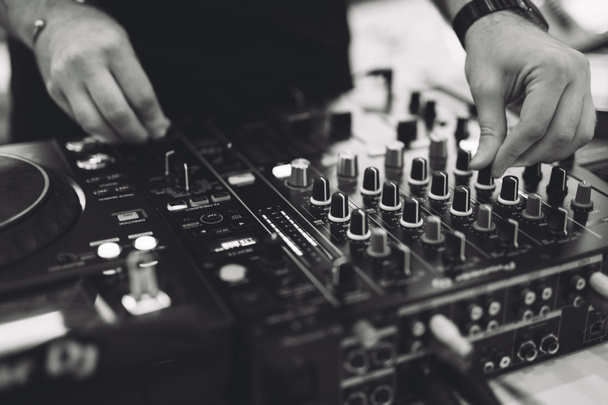 a DJ plays music on a controller at a party - Zdjęcie, obraz