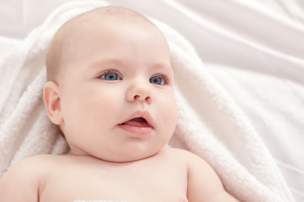Beautiful baby relaxing in bed after bath - Photo, Image