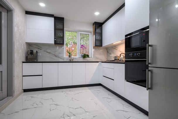 Remontoitu yksiö on valoisa, valkoinen keittiö marmori lattia ja moderni päättyy - Valokuva, kuva