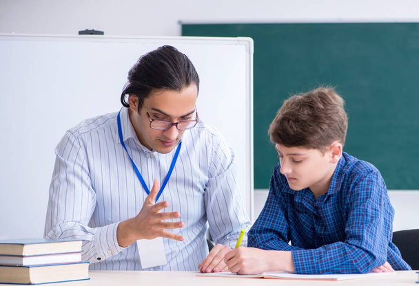 De jonge mannelijke leraar en jongen in de klas - Foto, afbeelding