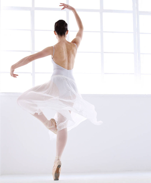 Ελευθερία στο χορό. Χαριτωμένη νεαρή μπαλαρίνα σε λευκό χορό en pointe - Φωτογραφία, εικόνα