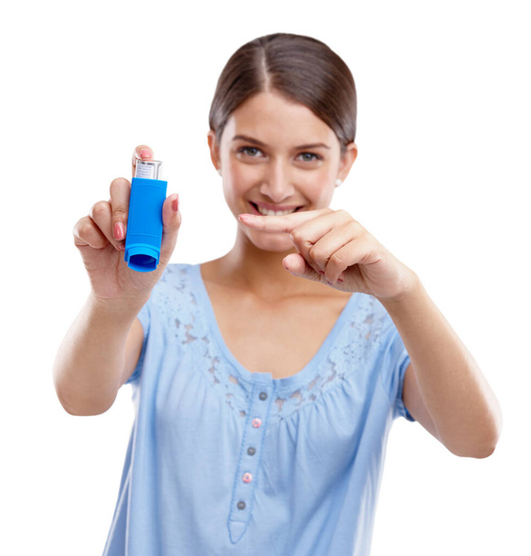 Woman, asthma pump and smile pointing inhaler for medical solution, respiratory or breathing against white studio background. Portrait of isolated female holding puffer to breathe, allergy or relief. - Foto, Imagem