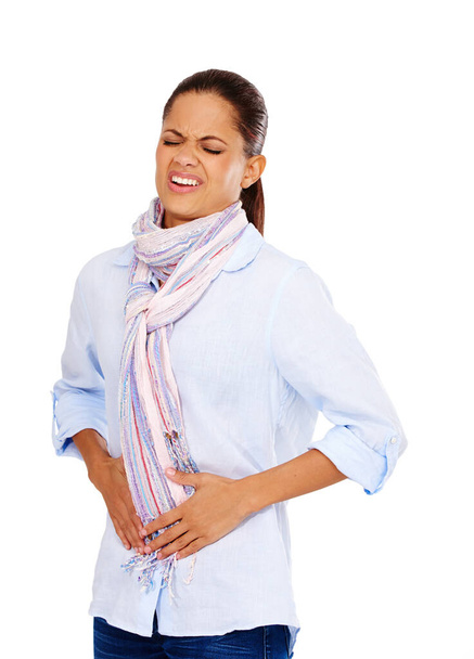 Colon, digestion or constipation and a model black woman in studio isolated on a white background with stomach pain. Menstruation, stomach ache and period with a hurt young female on blank space. - Photo, Image