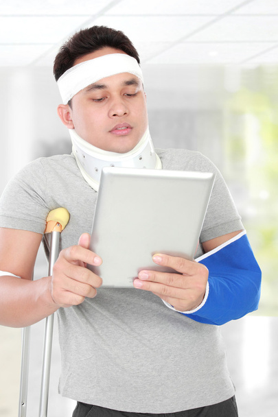 injured young man look serious use the tablet - Фото, зображення
