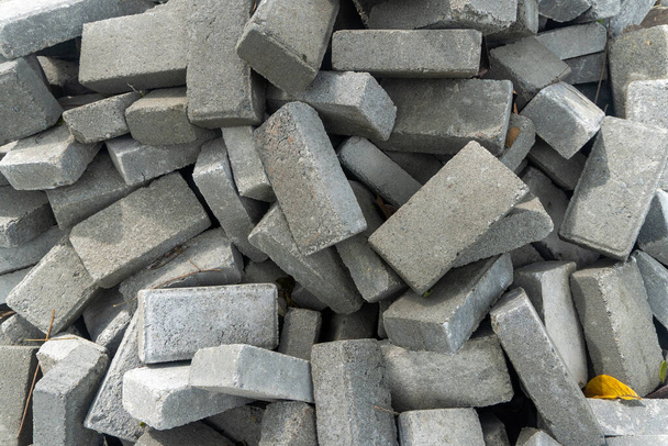 Σωρός από γκρίζα τούβλα τσιμέντου στη μέση μιας κατασκευής πάρκου κοντά - Φωτογραφία, εικόνα