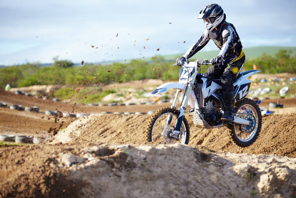 Leaving the competition in the dust. A motocross rider doing a stunt in the dirt - Foto, Bild
