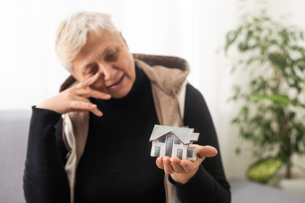 Happy realitní makléřka drží malý dům model po ruce, dlaň, ukazující objekt před kamerou, propagace agenturní služby, pomoc s domem, koupě nemovitosti byt pronájem, hypotéka - Fotografie, Obrázek