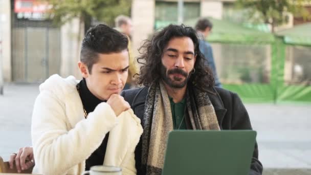 Slow motion of a gay couple stares at a laptop screen and suddenly gesticulates bad luck - Filmati, video