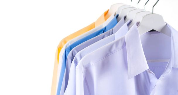 Πολύχρωμα πουκάμισα κρέμονται σε μια σχάρα, φόντο - Φωτογραφία, εικόνα