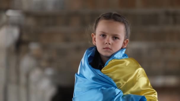 Portrait of a sad child with a Ukrainian flag. Migrant children from Ukraine. Russias aggression against Ukraine - Imágenes, Vídeo