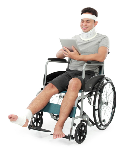 injured young man in wheelchair play gadget - Foto, Imagen