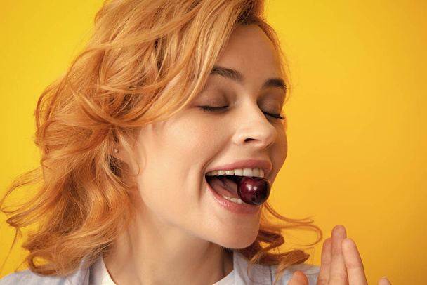 A nők szeretik a friss cseresznyét. A női száj édes cseresznyét eszik. Szoros női száj íze édes cseresznye - Fotó, kép