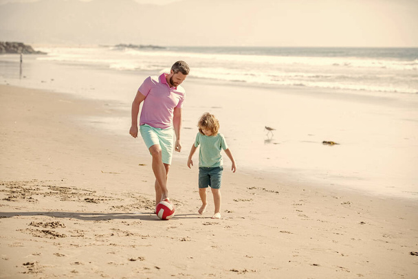 Hétvégi családi nap. Apa és a gyerek jól érzik magukat a szabadban. gyermekkor és nevelés. Családi nyaralás. sport tevékenység. Boldog apa és fia fociznak a parton. apa kisfiúval a nyári napon. - Fotó, kép