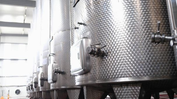 Modern automated winery with lines of metal tanks. Interior view of modern brewery with stainless steel barrels. Shop with a brewery - Foto, immagini