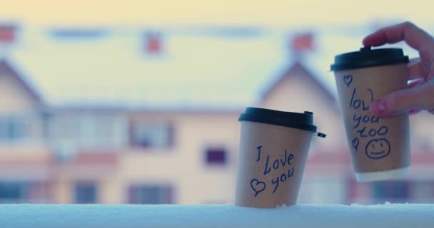 I love you and I love you too - male hand puts a glass of coffee in the snow with inscriptions. The concept of love and relationships. 4k slow motion. Video with copy space. - Imágenes, Vídeo