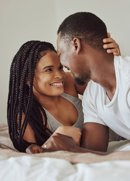 Black couple, love and home bedroom bonding while happy together on a bed in a house, apartment or hotel. Young man and woman intimate in a healthy marriage with commitment, happiness and care. - Foto, Imagem