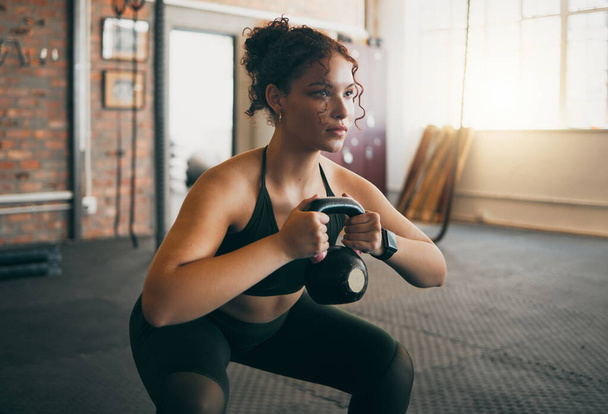 Fitness, kettlebell and a woman at gym doing workout, exercise and weight training for body wellness and muscle. Strong sports female or athlete with weights for power, energy and a healthy lifestyle. - Fotografie, Obrázek