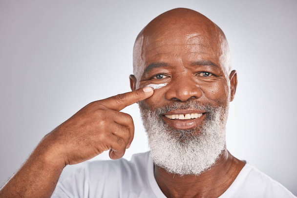 Beauty, facial cream and skincare of black man in studio for self care with lotion, dermatology and cosmetics. Face portrait of happy senior male with a product on skin for glow, health and wellness. - Foto, immagini