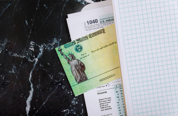 Masa 1040 bireysel gelir vergisi formu, kalem hesap makinesi ve dolar banknotları, vergi iadesi uyarıcısı çeki - Fotoğraf, Görsel