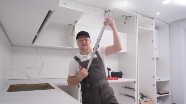 A young man pretending to play the guitar while renovating using a vacuum cleaner. Time to repair the house. A happy man in a new apartment - Filmmaterial, Video