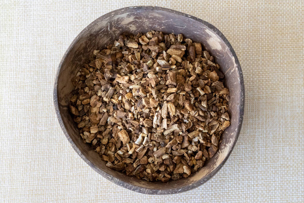 Burdock Root Herb Herbal Medicine In Natural Coconut Bowl on Beige Background. - Photo, Image