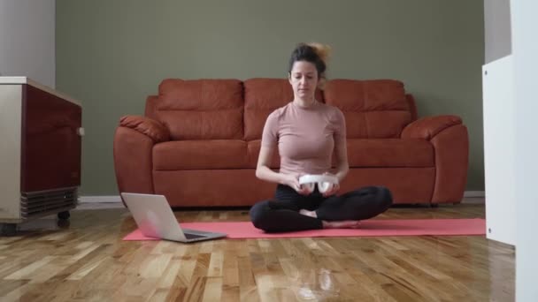 オンラインガイド付き瞑想のためのヘッドフォンを使用して1人の女性大人の白人女性千年紀自宅で床に目を閉じてマインドフルネスヨガを練習本当の人々のセルフケアの概念 - 映像、動画