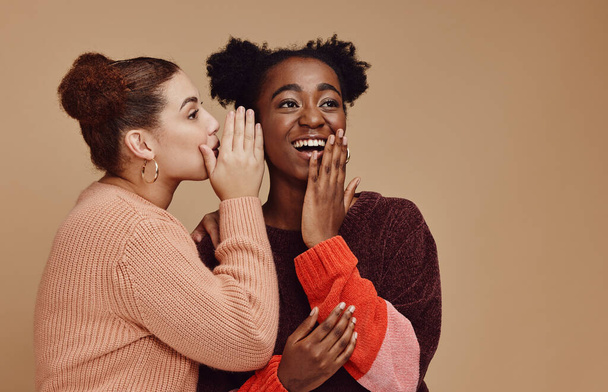 Friends, gossip and black woman laughing at secret on studio background and product placement mockup. Secrets, rumor and surprise whisper in ear, happy women smile discuss discount sale announcement. - Foto, Imagen