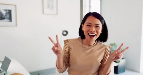 Creative asian woman, smile and peace signs walking into the office for happy, excited or positive vibes. Employee Japanese woman showing heart shape hand emoji and smiling in positivity for startup. - Filmagem, Vídeo