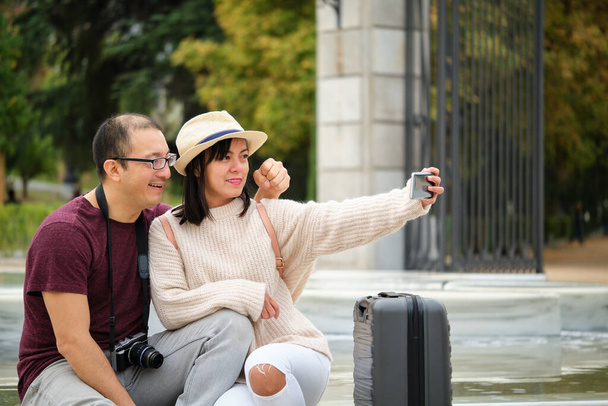 Una pareja multirracial de turistas tomando una selfie juntos. Turismo en Madrid, España. - Foto, Imagen