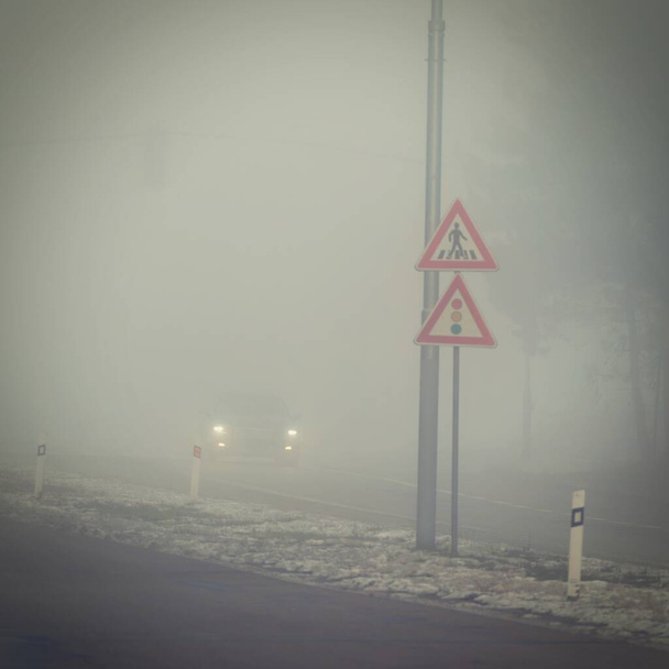 Cars in the fog. Traffic on the road in winter in bad weather. Dangers of driving cars. - Foto, imagen