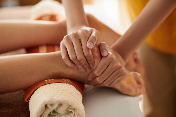 Массажистка делает массаж ног клиентке - Фото, изображение