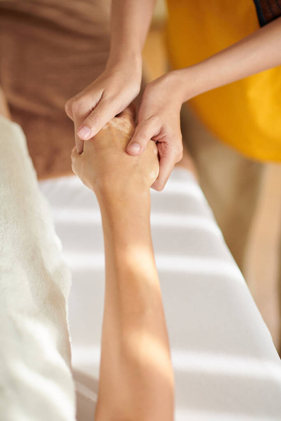 Женщина получает расслабляющий массаж рук в спа-салоне - Фото, изображение