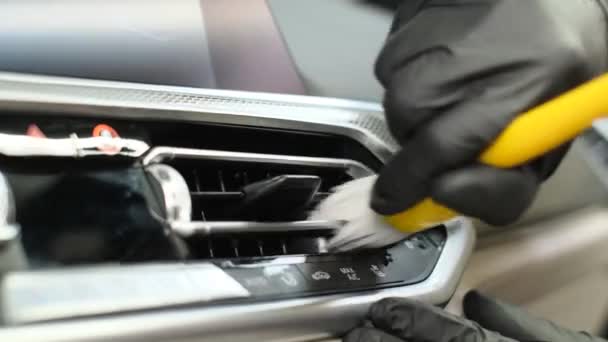 Πλένετε το εσωτερικό του αυτοκινήτου με ειδικό μαλακό πινέλο για τον καθαρισμό του πίνακα οργάνων. Επαγγελματικό πλυντήριο αυτοκινήτων στην υπηρεσία - Πλάνα, βίντεο