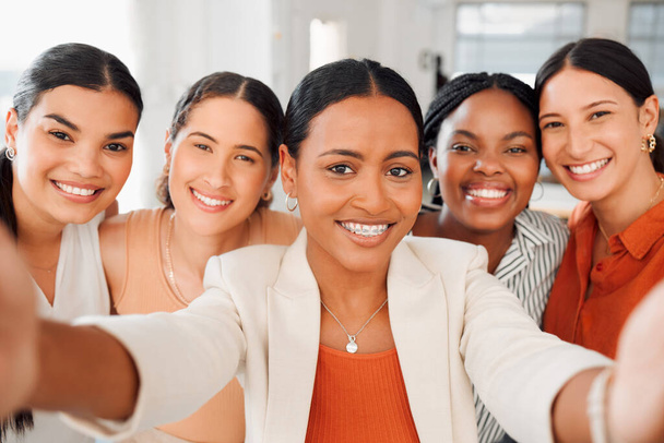 Portrait of a diverse group of five happy businesswomen taking a selfie together at work. Joyful businesspeople taking a photo in an office. Women working in corporate taking a picture. - Zdjęcie, obraz