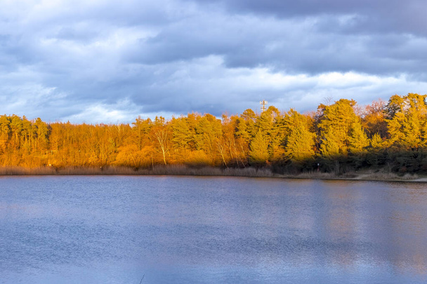 Kaunis pieni järvi nimeltä Oberwaldsee sinisen tunnin aikana Saksassa aurinkoisena päivänä syksyllä värikkään metsän heijastaessa vedessä.. - Valokuva, kuva