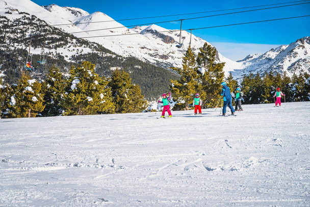 Ski instructor teaching a group of young kids how to ski in El Tarter green slope. Winter holidays in Andorra, Pyrenees Mountains, Grandvalira - Photo, Image