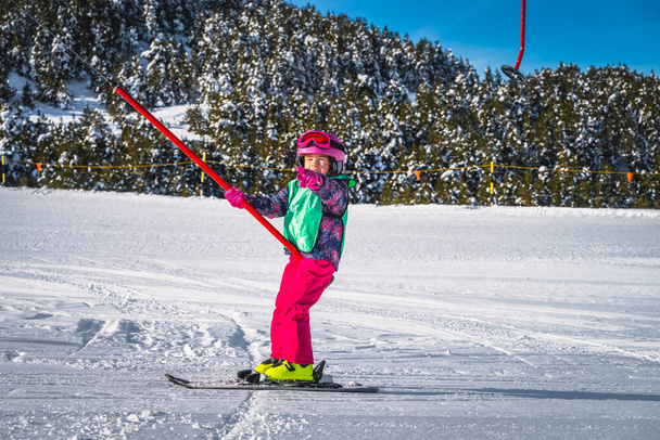Young skier, a child, having fun when riding up on a ski drag lift. Winter holidays in El Tarter, Andorra, Pyrenees Mountains, Grandvalira - Foto, imagen