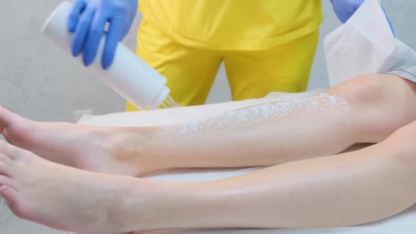 Waxing on a womans legs. Beauty salon for women. Depilation of the girls body. 4k video - Felvétel, videó
