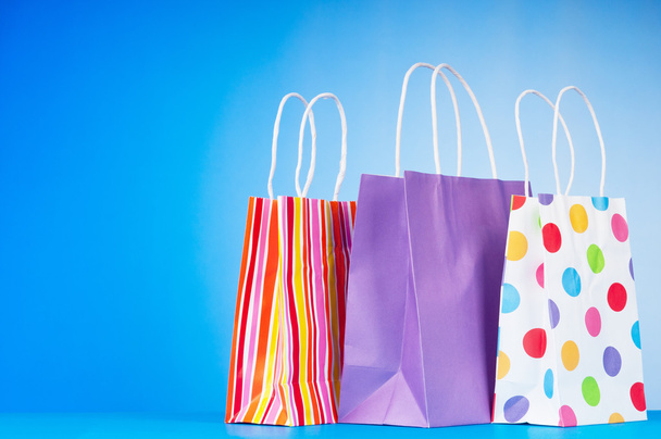 Colourful paper shopping bags against gradient background - Valokuva, kuva