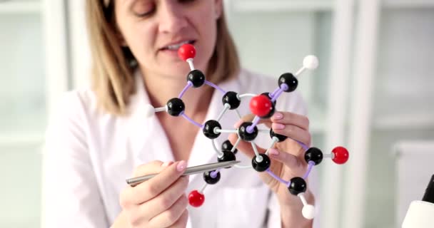 Female scientist looks at DNA mockup in laboratory. Most important methods of molecular biology and genetic engineering - Video
