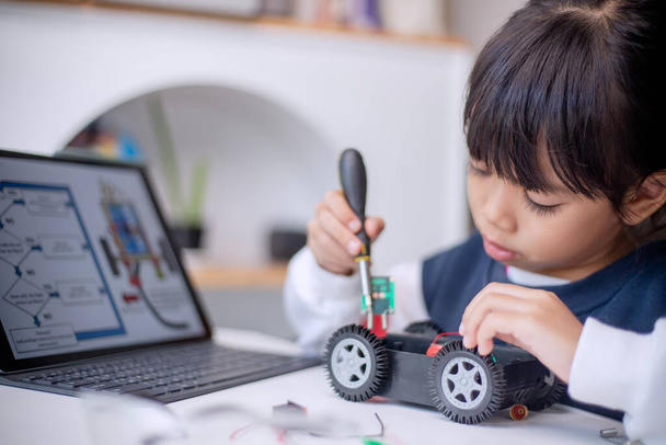 Asia students learn at home in coding robot cars and electronic board cables in STEM, STEAM, mathematics engineering science technology computer code in robotics for kids concept - Photo, Image