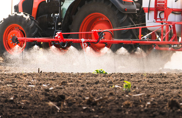 Traktor postřikuje pesticidy na poli postřikovačem  - Fotografie, Obrázek